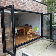 Black bi-folding doors opening on to the patio - conservatory doors